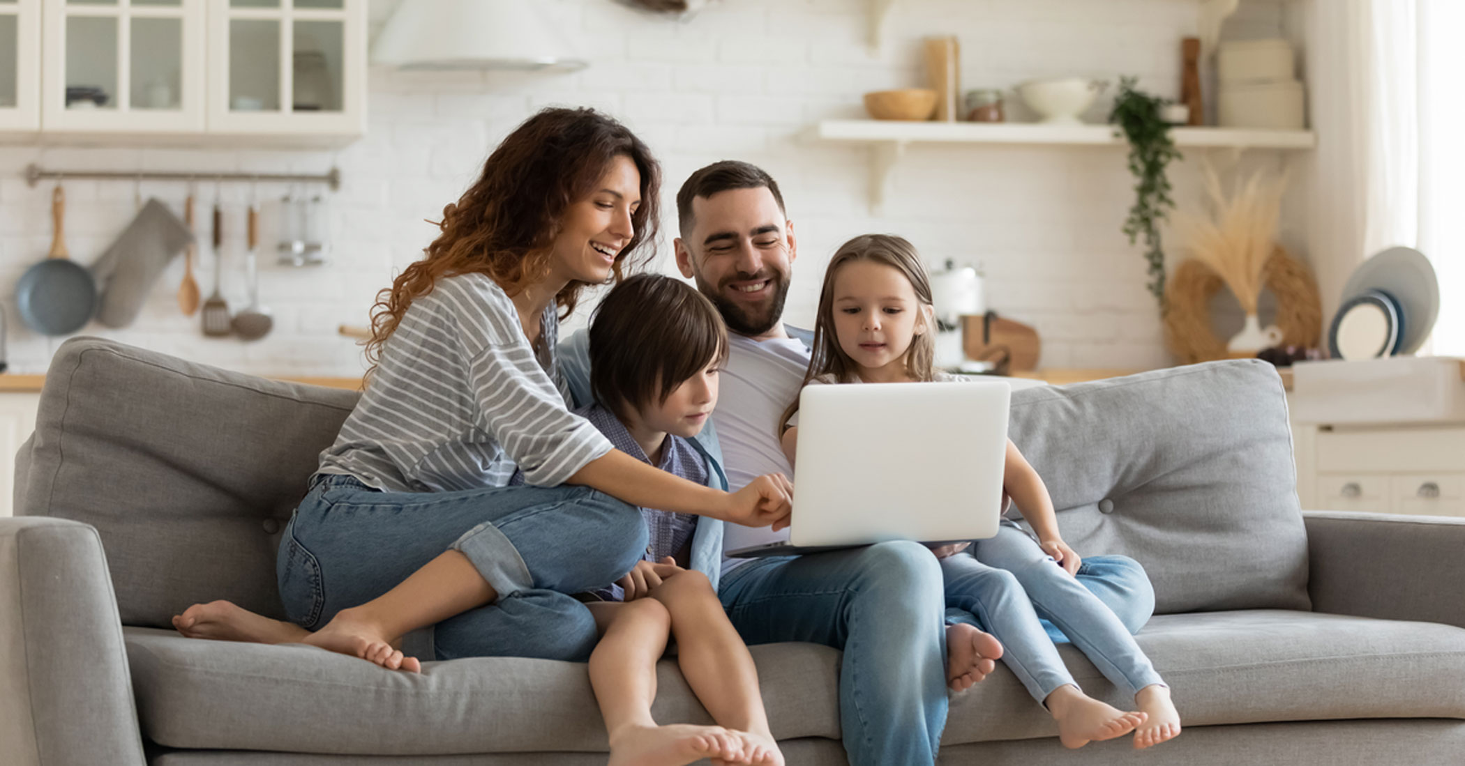 Family on a couch looking at a laptop