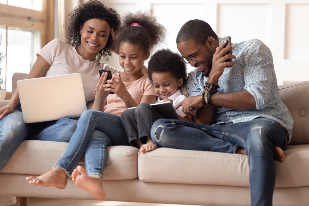 Family on couch playing with mobile devices