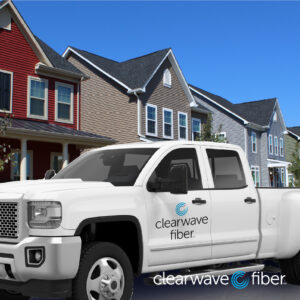 White truck with Clearwave Fiber logo parked outside a row of homes